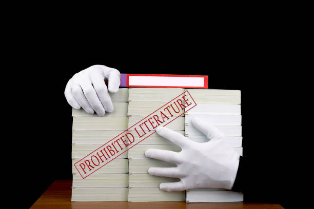 A red hardback book with a cutaway area in the pages concealing a stack of euro notes on an isolated background