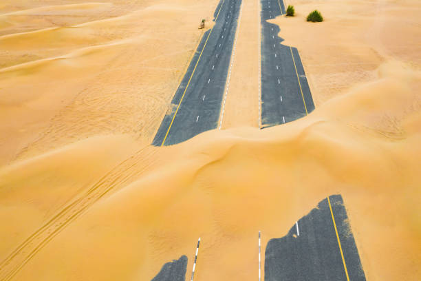 vista dall'alto, splendida vista aerea di una strada deserta coperta da dune di sabbia nel mezzo del deserto di dubai. dubai, emirati arabi uniti. - 7292 foto e immagini stock