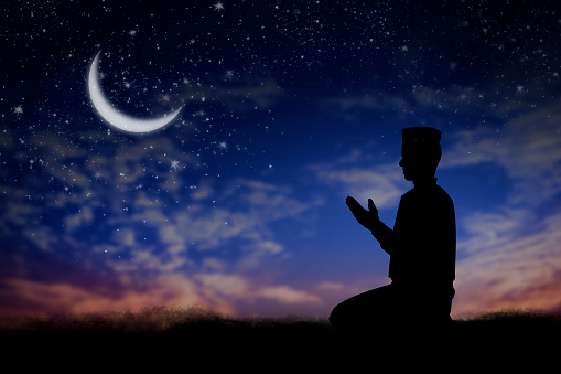 Silhouette young male muslim prayer with hijab praying to God front of landscape view. concept for eid mubarak,