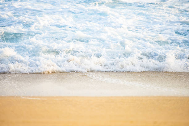 (foco seletivo) vista deslumbrante de ondas batendo em uma linda praia durante o pôr do sol. ilha lombok, west nusa tenggara, indonésia. - high tide - fotografias e filmes do acervo