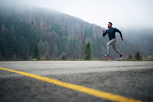 Athlete practicing sprint running outdoor in nature.