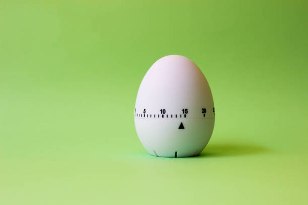 istock White egg timer on green background. Happy Easter in the kitchen. Home related, home staying. Free copy space. Flat lay 1218004946