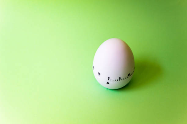 istock White egg timer on green background. Happy Easter in the kitchen. Home related, home staying. Free copy space. Flat lay 1218004975