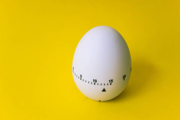 istock white egg timer on yellow background. Happy Easter in the kitchen. Home related, home staying 1218004991