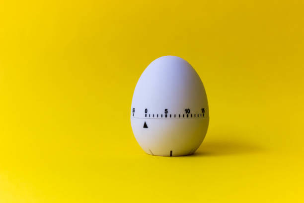 white egg timer on yellow background. Happy Easter in the kitchen. Home related, home staying