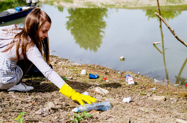 istock Girl Volunteer Cleaning river beach from the garbage 1218008380