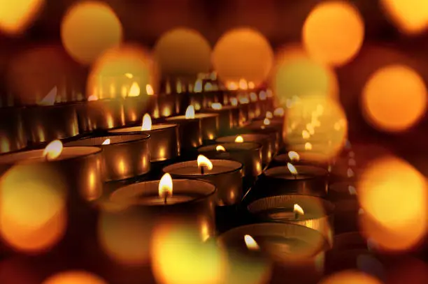 Close-up of a group of votive candles, tea lights, with bokeh effect. Warm background