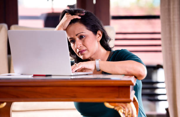 istock Frustrated woman reading document at home office 1218011095