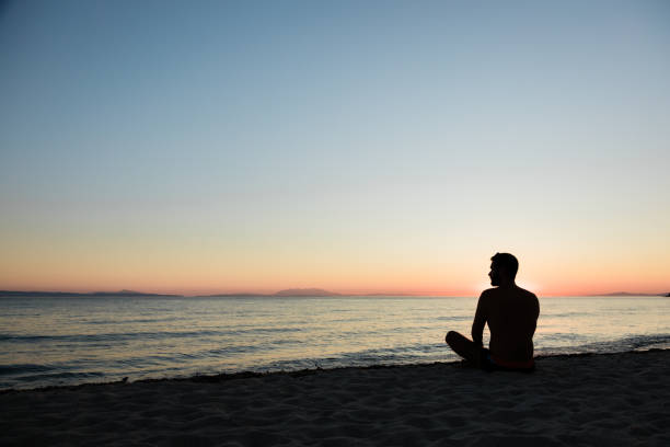 istock Young man enjoying sunset on the beach 1218013036