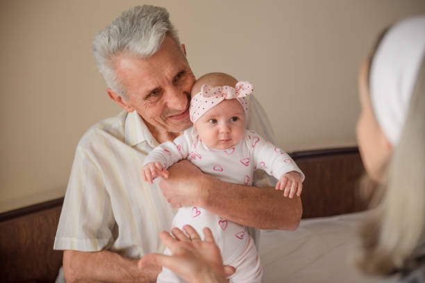 Happy girl with her's grandparents. Grandfather kissing her