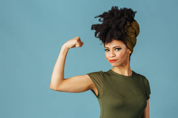 retrato de una joven mostrando su brazo y su fuerza - motivación fotos fotografías e imágenes de stock