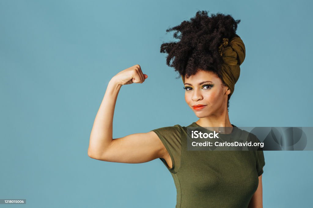 Portrait of a young woman showing her arm and strength Women Stock Photo