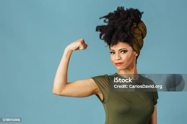 Portrait Of A Young Woman Showing Her Arm And Strength Stock Photo - Download Image Now