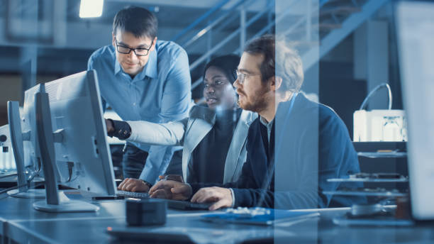 electronics development engineer werken aan computer, gesprekken met project manager, een andere specialist sluit zich aan bij discussie. team van professionals gebruiken cad-software voor modern industrieel ontwerp. - fabricage apparatuur fotos stockfoto's en -beelden