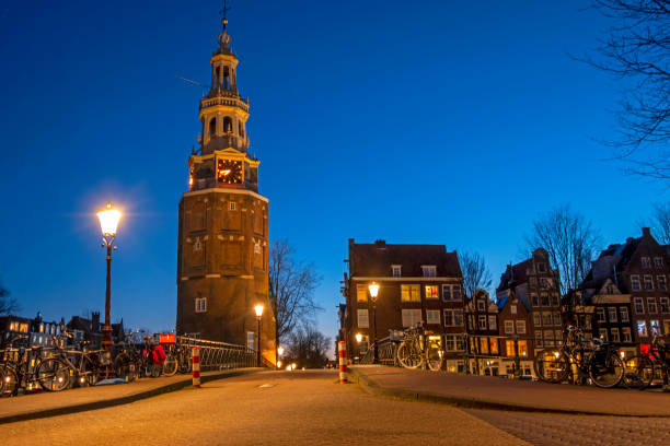 башня монтельбаан в амстердаме, нидерланды, ночью - montelbaan tower стоковые фото и изображения