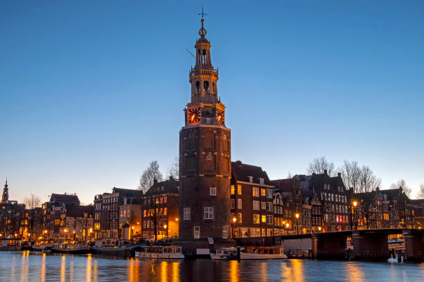 город живописный из амстердама с башней монтельбаан в нидерландах на закате - montelbaan tower стоковые фото и изображения