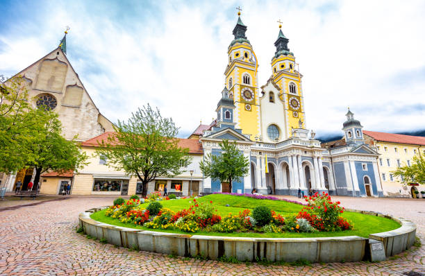 Cathedral watchtowers clock tower buildings exterior central old city square marketplace, Brixen Bressanone, South Tyrol Alto Adige, Italy tourism.