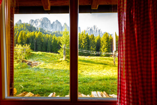 istock View through window mountain ridge grassland forest, South Tyrol, Italy. 1218024967