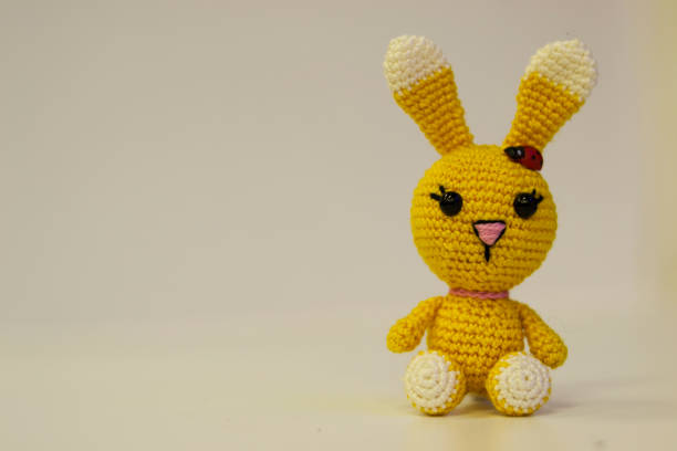 istock Amigurumi yellow hare sitting on a white background. Needlework concept. 1218027427