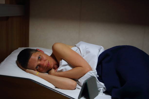 istock One mature woman laying in bed with eReader smiling and looking at camera 1218029529