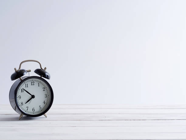 Old clock on white wooden plank floor vintage style.