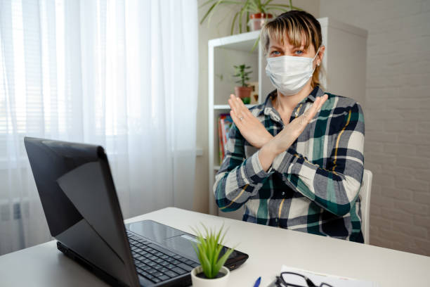 istock Remote working. Woman in medical mask working remotely from home 1218031111
