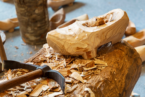 Handamade rustic wooden clog, usually with small studs on the sole and finished with a pointed upturned toe.