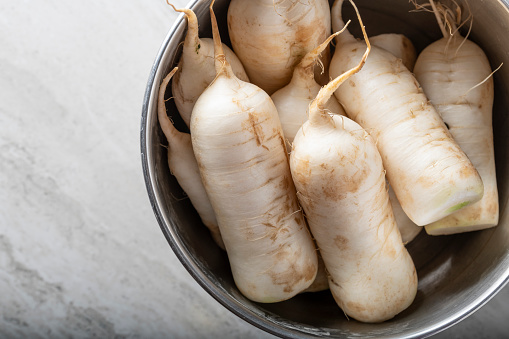 Raw white radish in a stainless container.