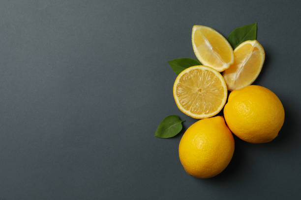istock Fresh lemons with leaves on black background, top view. Ripe fruit 1218034003