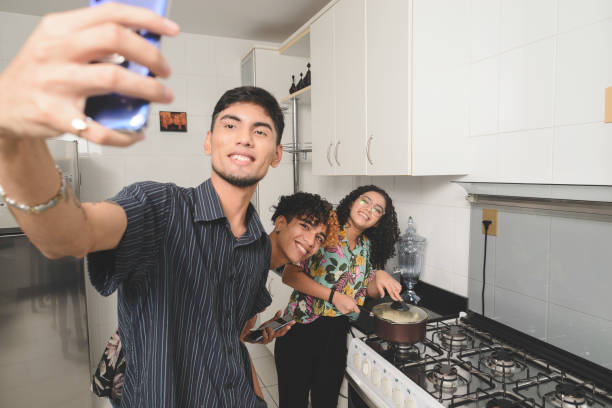 istock Millennial multi-ethnic flatmates taking selfie while cooking popcorn together 1218034302