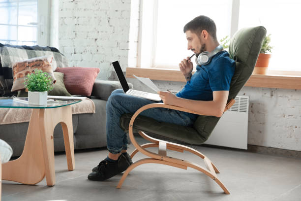 istock Young focused man studying at home during online courses or free information by hisself 1218034697