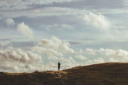 A woman walking on the hills at the North Sea coast in Brora Village, Highlands of Scotland, UK