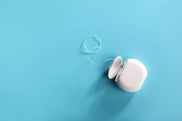 Dental floss on blue background Top view of dental floss on blue background. Copy space dental floss stock pictures, royalty-free photos & images