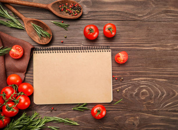 istock Recipe book, tomatoes, rosemary and wooden kitchenware 1218038414