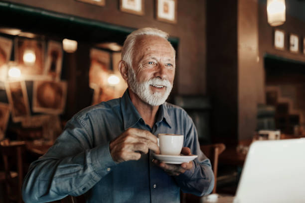 Senior businessman drinking coffee and using laptop computer