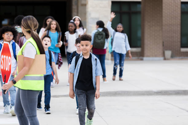 istock Group of schoolchildren on crosswalk 1218040925
