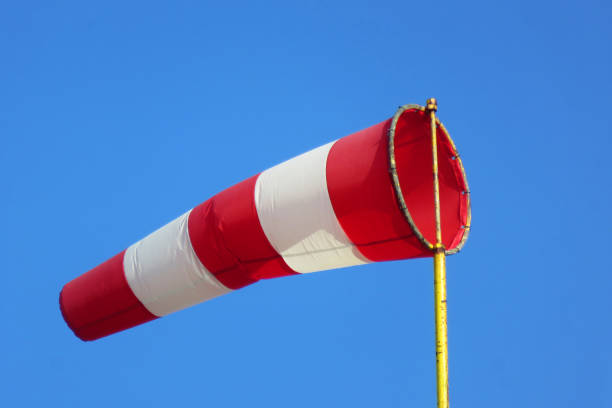 istock Windsock indicator of wind on runway airport.  Wind cone indicating wind direction and force. Horizontally flying windsock (wind vane) with blue sky in the background. 1218042067