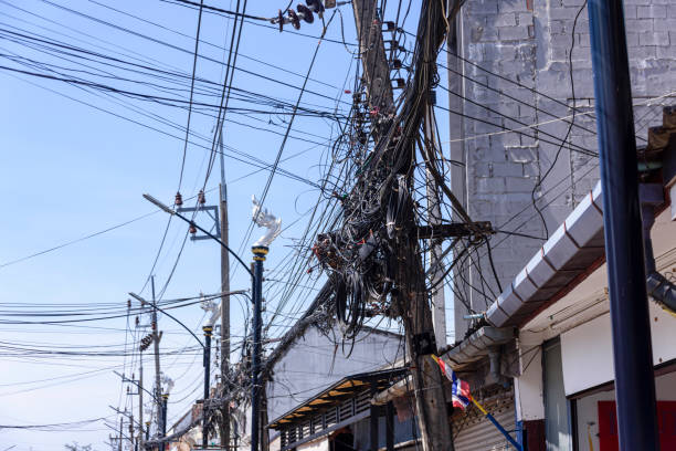 грязные и неопрятные электрические кабели, свисаные с электрического столба в таиланде - electricity chaos cable connection стоковые фото и изображения