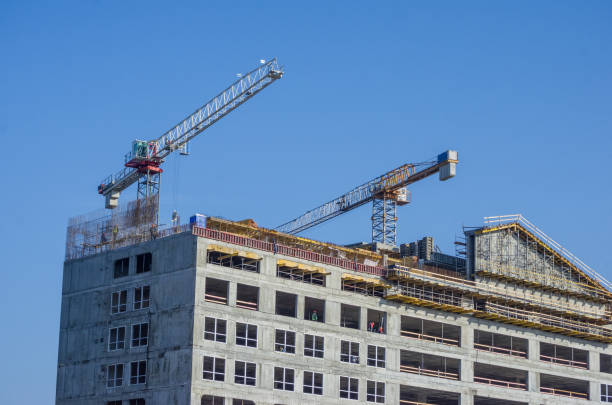 istock Building crane and building under construction against blue sky 1218046172
