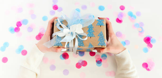 istock Crop woman carrying gift box over confetti 1218047717