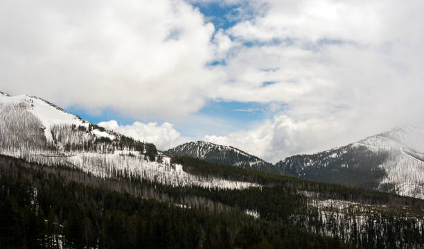 istock Snow-capped mountains under a blue sky with clouds 1218048561