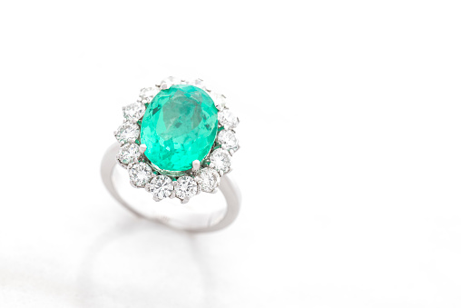 Ring with diamonds and turquoise diamond on white background.