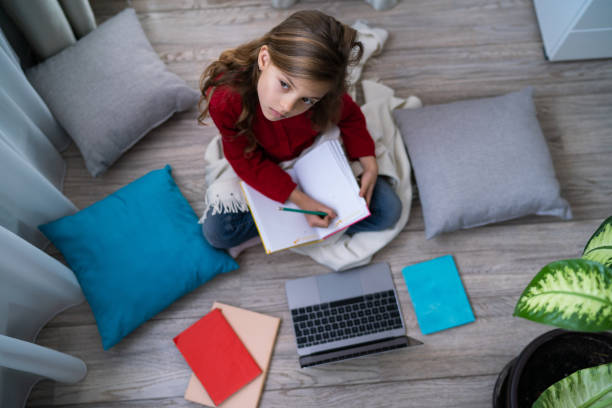 istock Cute girl on the floor writing in notebook 1218049990