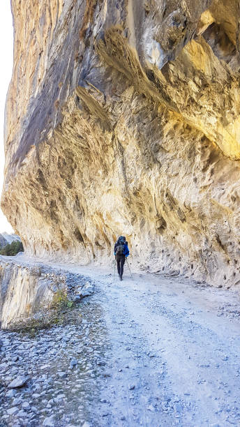 istock Hongde - A man hiking under a hanging mountain wall 1218051133