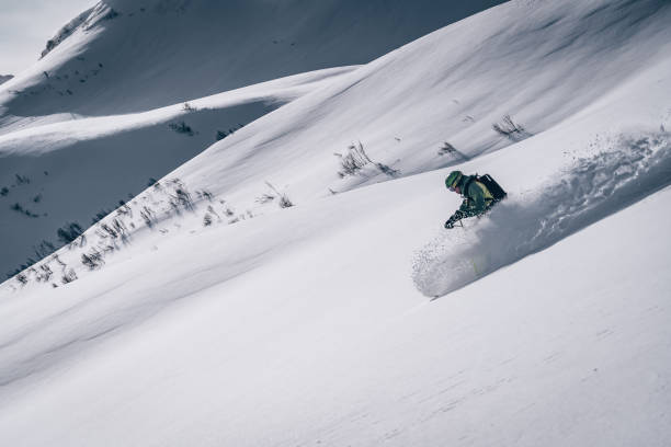 backcountry skifahrer steigt berg - telemark skiing stock-fotos und bilder