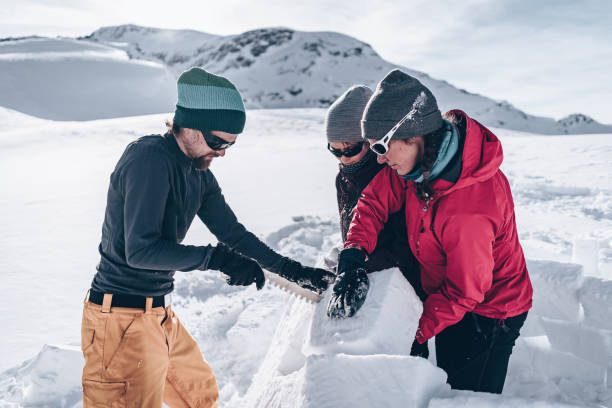 istock Friends carve snow to build igloo 1218052828