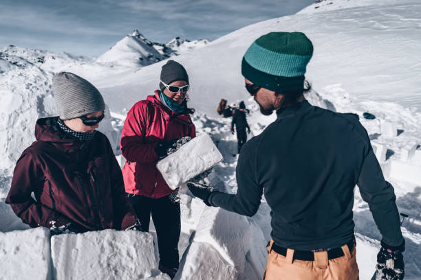 istock Friends carve snow to build igloo 1218052871