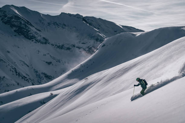 backcountry skifahrer steigt berg - telemark skiing stock-fotos und bilder
