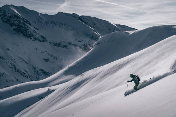 esquiador de fondo desciende montaña - skiing snow skiing helmet fun fotografías e imágenes de stock