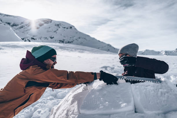istock Friends carve snow to build igloo 1218053512